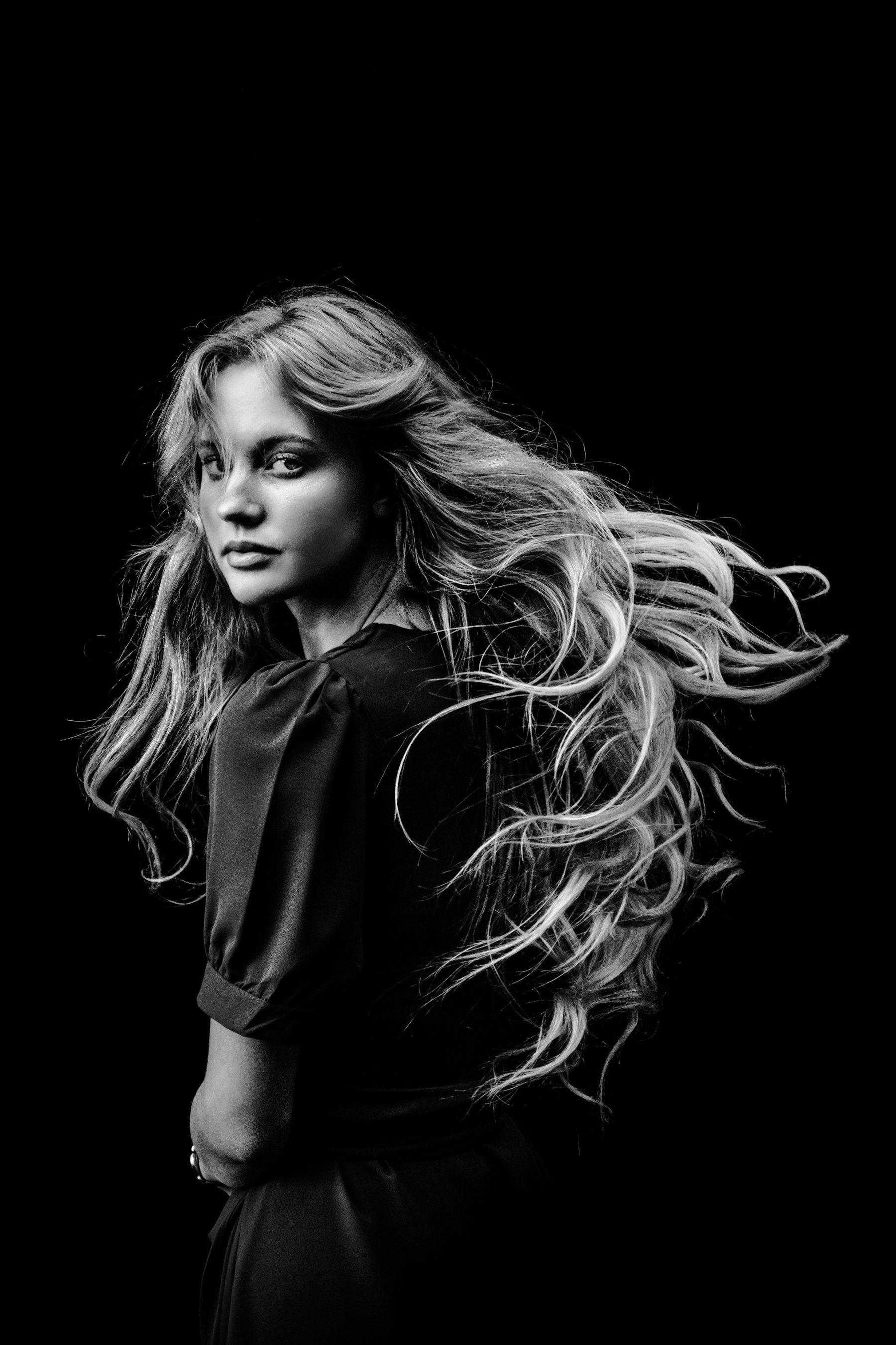 Black and white portrait with long hair caught in movement